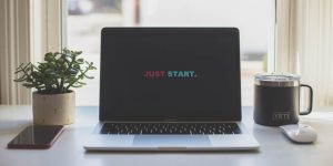 Laptop screen reads "just start" an encouragement to launch MVP